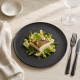 Assiette plate Roda ardoise 28 cm dressée avec un plat de poisson et des légumes verts – présentation non incluse