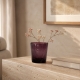 Petit vase pourpre en verre craquelé avec fleurs séchées dans un intérieur chaleureux