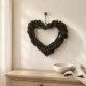 Coeur décoratif en branches de bois  suspendu au dessus d'une console