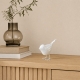 Oiseau blanc Luftikus en métal sur une console en bois clair