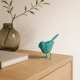 Oiseau bleu turquoise Luftikus sur une console en bois clair