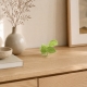 Petit oiseau vert anis Luftikus sur une console en bois clair