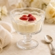 Coupe sur pied présentée avec une crème et des fruits rouges.