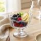 Coupe à dessert sur pied en verre présentée avec des fruits frais
