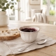 Ramequin « Impressions » blanc de 10 cm présenté avec de la confiture au petit-déjeuner.