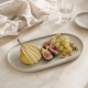 Le plat ovale Nótos mis en scène sur une table claire. Aliments et accessoires non inclus.