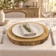 Rondelle en bois brut utilisée en sous- assiette avec vaisselle ivoire et serviette en lin.