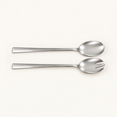 Deux couverts à salade en inox poli Hermann Bauer sur fond ivoire, cuillère et couvert ajouré.