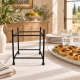 Support Notos présenté sur un buffet en lin clair auprès d’un plat et d’assiettes.