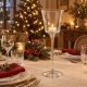 Photophore conique en verre sur une table de Noël en lin naturel, avec serviettes rouges et décor de sapin.