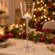 Trois photophores coniques sur pied en verre illuminent une table de Noël, entre nappe en lin naturel, branches de sapin et touc